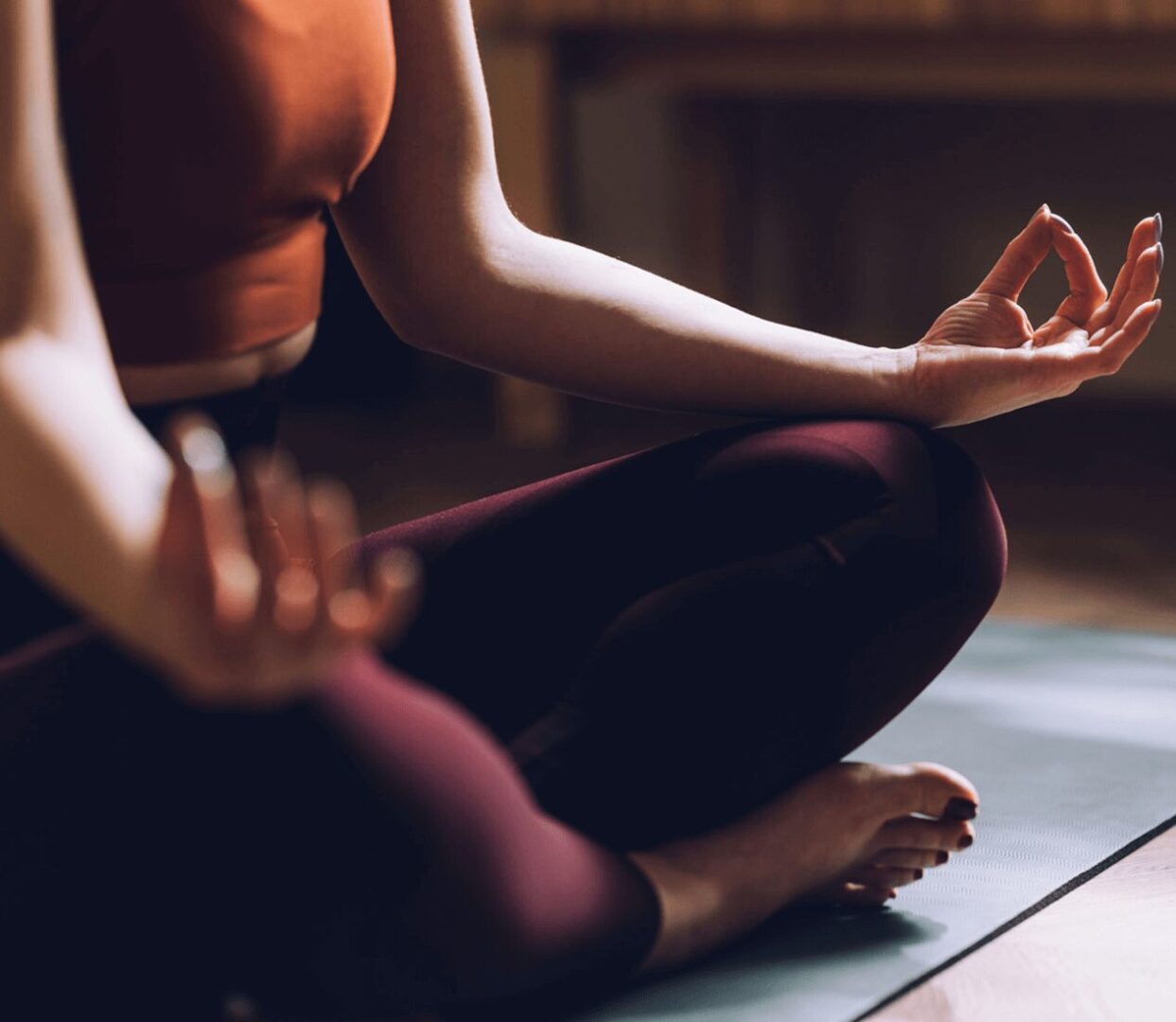 Person meditating in a yoga pose indoors.