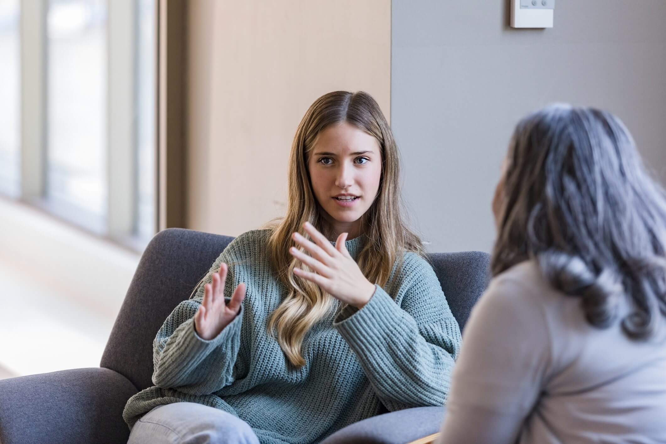 Woman explaining something during a conversation indoors.