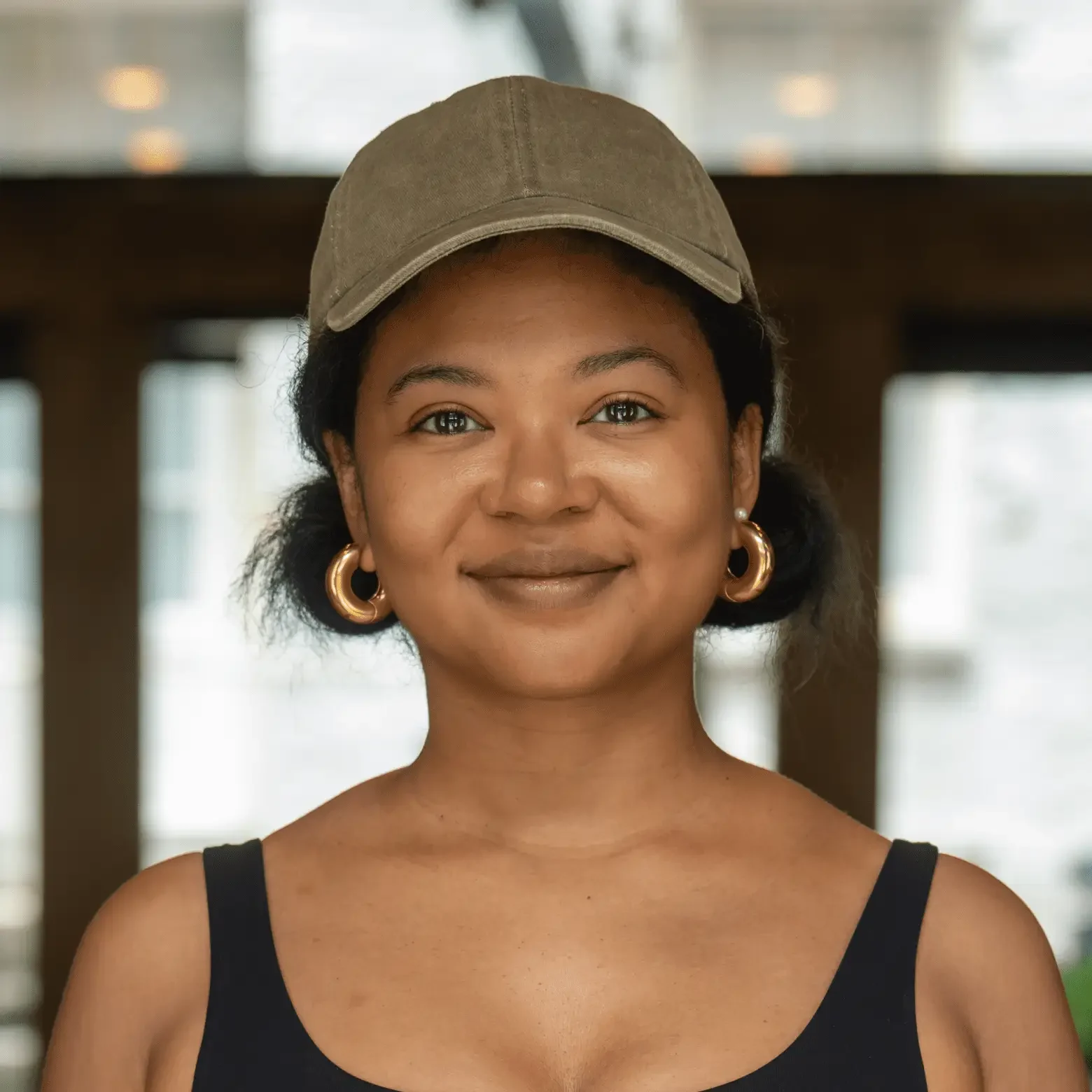 Smiling woman wearing cap and hoop earrings